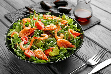 Plate with tasty shrimp salad on table