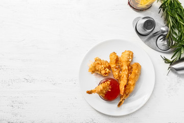 Plate with tasty shrimps and tomato sauce on white table