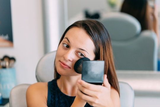 Brunette woman putting makeup on at a spa center