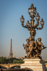 Fototapeta na wymiar Angels lamps of Alexandre III bridge with the Eiffel Tower in Paris