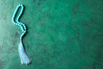 Muslim beads on color background