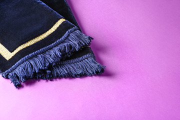 Muslim prayer mat on color background