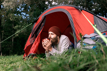 Young man drinking tea in the woods