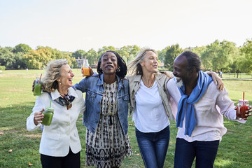 Group of friends singing and dancing at park. Senior people.