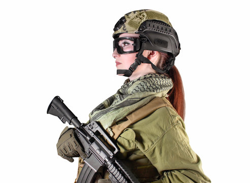 Side view portrait of young fully equipped military soldier woman holding an automatic rifle M16, isolated photo.