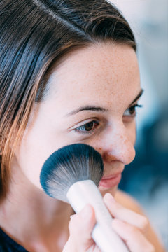 Brunette woman putting makeup on at a spa center