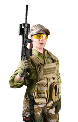 Beautiful fully equipped military soldier woman in protective armor tactical vest, camouflage pants, gloves, cap and glasses holding an automatic rifle M16, isolated photo.