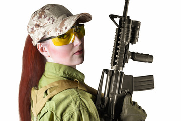 Portrait of young and beautiful military soldier woman with red hair holding an automatic rifle M16, isolated photo.