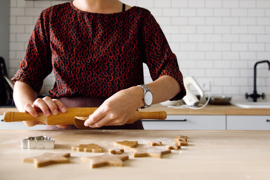 Woman rolling cookie dough with rolling pin