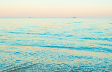 Beautifu blue sea water background. Beautiful pink color sunset on the beach.