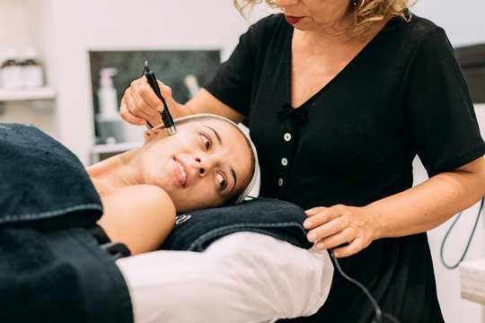 Woman applying skin treatment at spa center