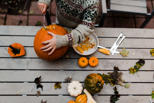 view from above of boy carving a pumpkin
