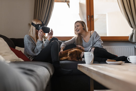 Laughing women with VR goggles at home