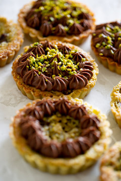 Pistachio frangipane tartlets topped with chocolate cream