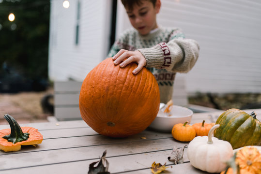 boy carving a big pumpkin