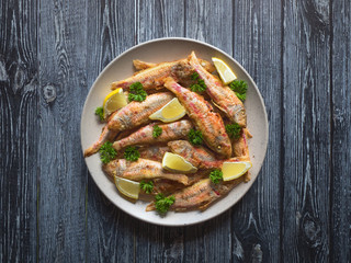 Fried fish on a plate. Dietary surmullet fish. 