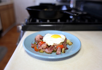 Plate of corned beef hash with a fried egg sunny side up.