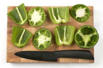 sliced sweet peppers with a ceramic knife on a wooden board