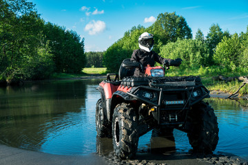 ATV in nature. Outdoor activity. Quad bike rides. Extreme sport. Forest, nature, river, field.
