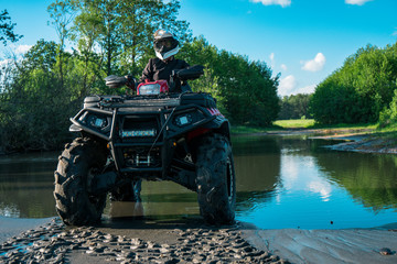 ATV in nature. Outdoor activity. Quad bike rides. Extreme sport. Forest, nature, river, field. © ValerAnDim