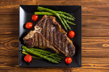 Grilled T-bone steak with asparagus and cherry tomatoes