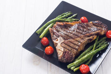 Grilled T-bone steak with asparagus and cherry tomatoes