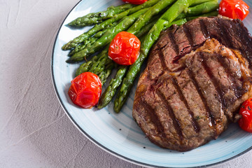 Grilled beef steak ribeye with cherry tomatoes and asparagus