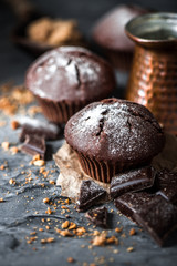 Muffin with coffee on dark textured background.
