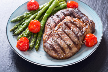 Grilled beef steak ribeye with cherry tomatoes and asparagus