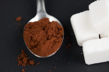Coffee spoon and sugar cubes isolated on a black background