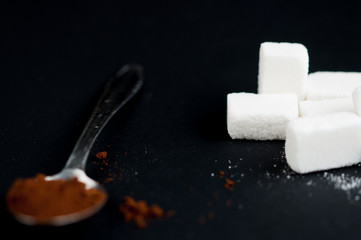Coffee spoon and sugar cubes isolated on a black background