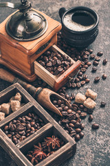 Obraz na płótnie Canvas Coffee with coffee grinder and coffee beans on dark textured background.