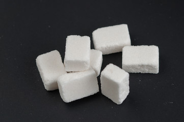 White sugar cubes isolated on black background.