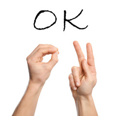 Man showing word okay on white background, closeup. Sign language