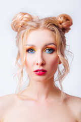 Fototapeta premium Young blonde girl with an original hairstyle and bright professional makeup
