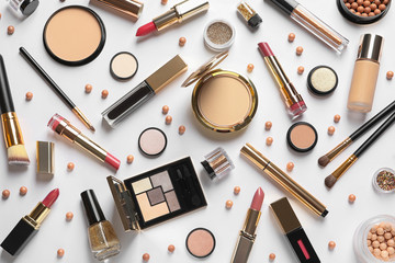 Different luxury makeup products on white background, top view