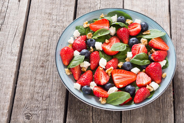 Summer Strawberry salad with spinach , cheese , nuts and blueberry