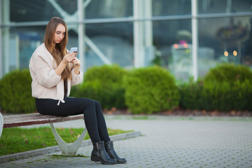Fototapeta na wymiar Depressed woman sitting in a city park on a bench