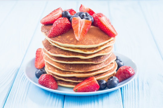 Tasty pancakes with blueberry and strawberry