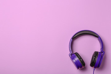 Stylish modern headphones on color background, top view. Space for text