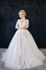 Fototapeta premium Studio portrait of a young girl of the bride with professional wedding makeup and hairdo.