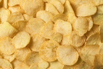 Crispy potato chips as background, top view