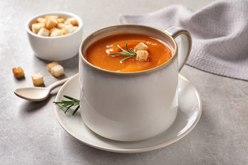 Mug of tasty sweet potato soup served on table