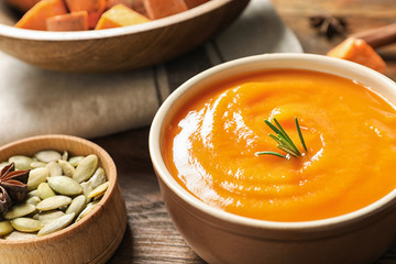 Bowl of tasty sweet potato soup served on table