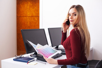 Portrait Of Happy Young Businesswoman Sitting At Desk While Working