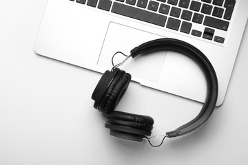 Modern headphones and laptop on white background, top view
