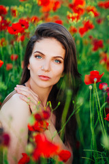 Naklejka premium Beautiful young girl in poppy fields at sunset. 
