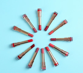 Flat lay composition with different stylish lipsticks on color background, space for text