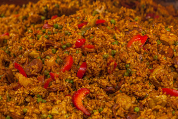 Traditional paella with chicken, sausage chorizo and vegetables served in paellera.