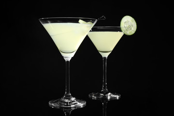 Glasses of delicious cucumber martini on dark background